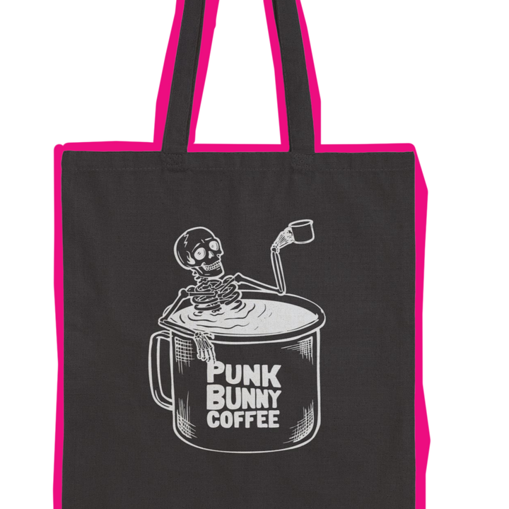 Black tote bag with pink handles featuring a skeleton and coffee cup design, labeled 'Punk Bunny Coffee'.